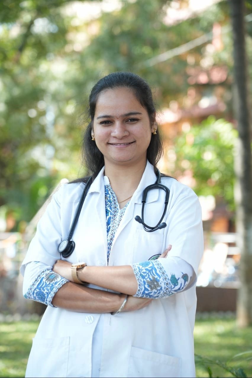 Dr. K. Jayalalitha, BHMS, smiling in a white coat with a stethoscope